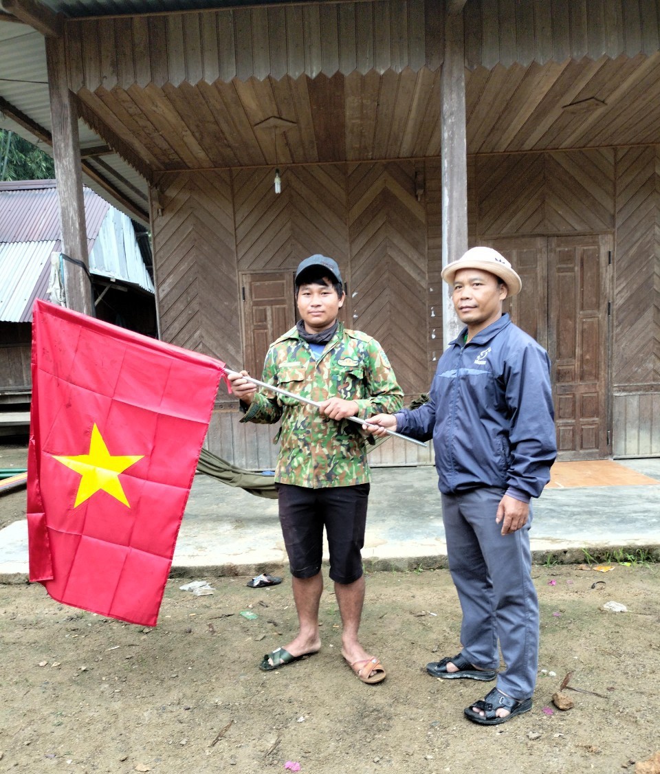 Đ/c Pơ Loong Diệu - CT HND huyện Nam Giang tặng cờ Tổ quốc cho HVND
